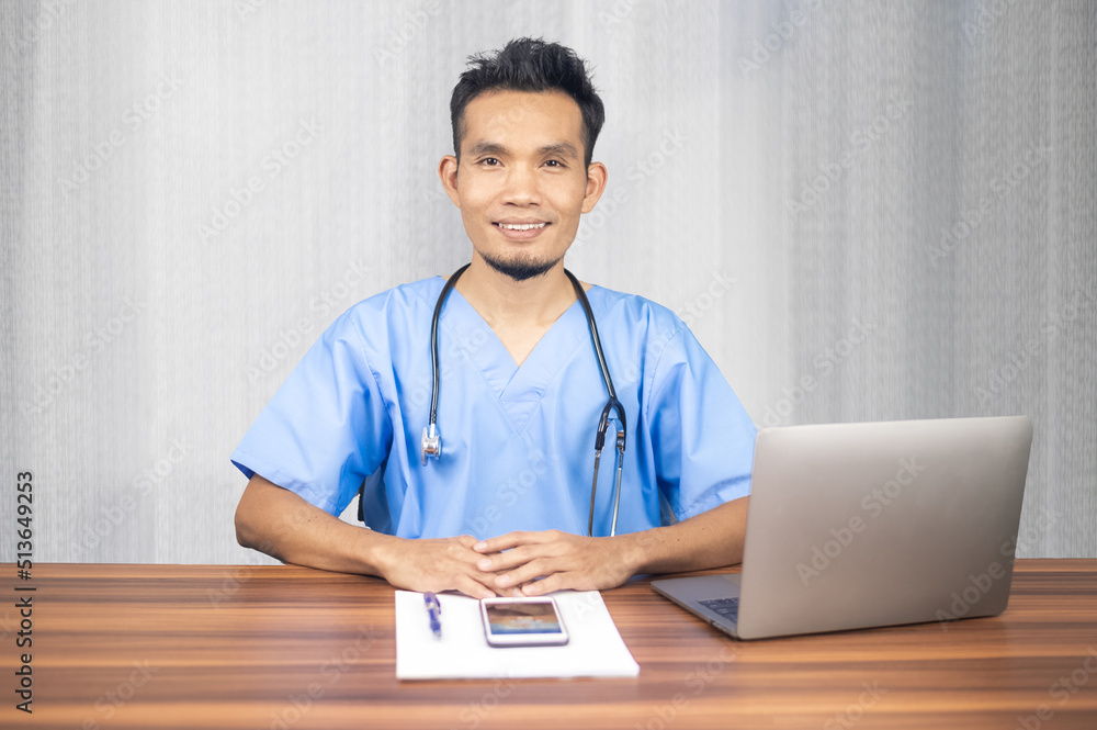 Wall mural asian doctor working laptop computer in office at hospital, doctor giving online consultation to his