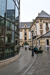 Fototapeta premium Glasfassade und Torbogen an der University of Wrocław, Universität, mit Blick auf die schön verzierten Gebäude der Altstadt, Breslau, Polen
