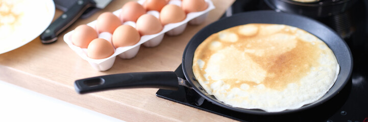 Thin pancake in a frying pan, cooking at home