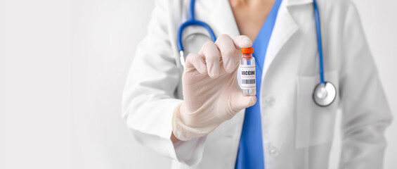 Female doctor with monkeypox vaccine on light background with space for text, closeup