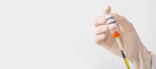 Doctor's hand with monkeypox vaccine and syringe on light background with space for text