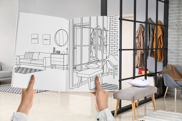 Designer holding sketchbook with drawing of new hallway interior in studio apartment