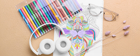 Coloring page with set of felt-tip pens, headphones and eyeglasses on beige background