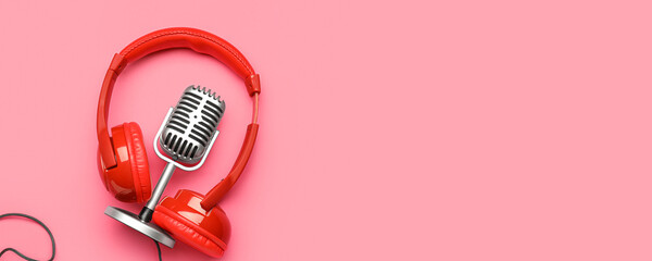 Headphones with microphone on pink background with space for text