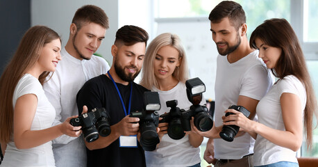 Group of young photographers during master class in studio - obrazy, fototapety, plakaty