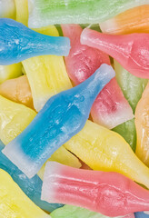 Wax Bottles candy scattered with assorted colors and flavors. Directly above flat lay macro.