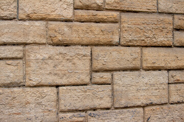 Vintage exterior stone block wall texture background, with rectangular blocks of varying sizes and shapes