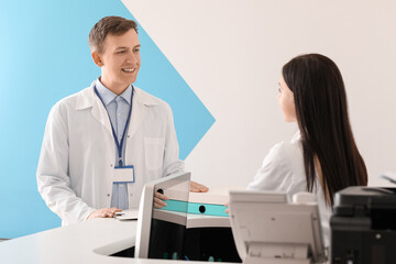 Fototapeta premium Doctor with receptionist at desk in clinic