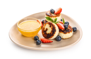 Plate with delicious cottage cheese pancakes, berries, mint leaves and honey on white background