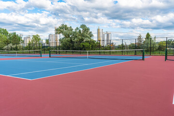 New blue tennis courts with white lines and red out of play area.	