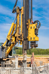 Hydraulic drilling machine at the construction site. Pile field. Modern drilling rig. The device of piles on the background of the blue sky. Work drilling rig when driving bored piles.