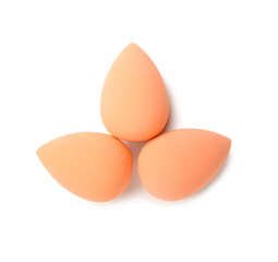 Orange makeup sponges on white background, top view
