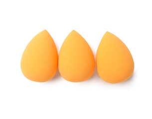 Orange makeup sponges on white background