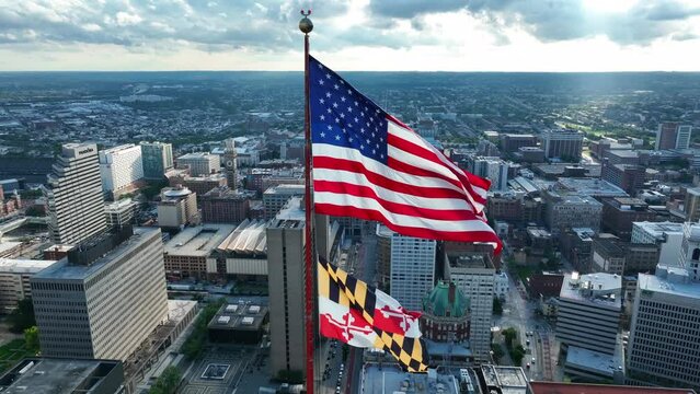 State of Maryland flag in downtown Baltimore MD USA. Aerial orbit of flags on summer day.