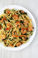 Homemade One-Pot Lemon Garlic Shrimp Pasta on a Plate on a white wooden background, top view. Flat lay, overhead, from above.