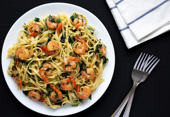 Homemade One-Pot Lemon Garlic Shrimp Pasta on a Plate on a black background, top view.