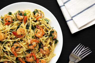 Homemade One-Pot Lemon Garlic Shrimp Pasta on a Plate on a black background, top view.