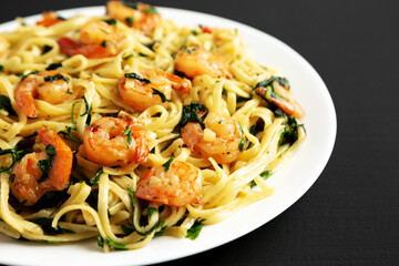 Homemade One-Pot Lemon Garlic Shrimp Pasta on a Plate on a black background, side view.