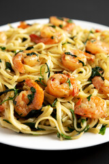 Homemade One-Pot Lemon Garlic Shrimp Pasta on a Plate on a black surface, side view.