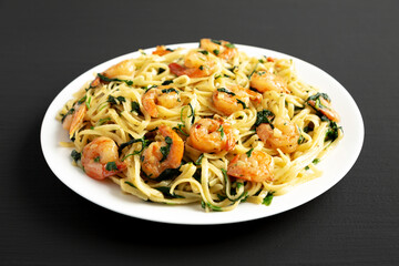 Homemade One-Pot Lemon Garlic Shrimp Pasta on a Plate on a black background, side view.