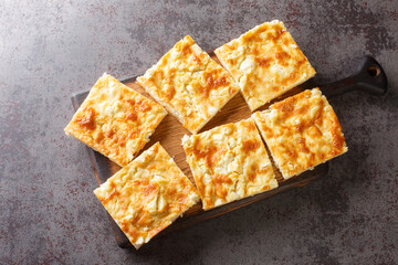 Alevropita Greek pie consisting of a thin batter that is sprinkled with feta cheese close-up on a...