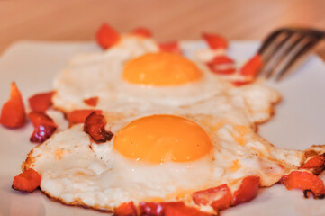 Two Fried eggs on pan with red pepper morning breakfast
