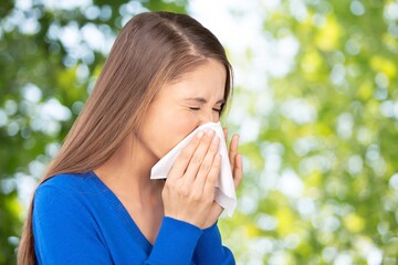 Woman allergic suffering from seasonal allergy at spring garden. Spring allergy concept