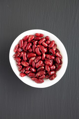 Red Organic Kidney Beans in a White Bowl on a black background, top view.