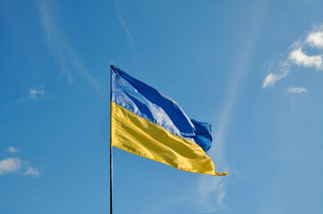 Blue and yellow Ukrainian flag in cloudy sky