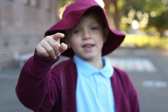 School child pointing towards the camera