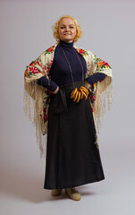 a woman in a Russian headscarf and a bundle of bagels stands in full growth on a white background