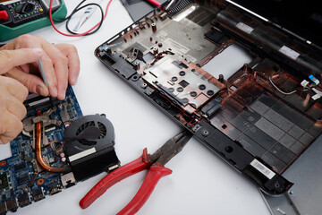 a computer repairman disassembles, repairs and does preventive maintenance for a broken laptop.