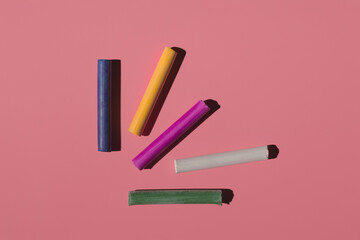 colored crayons on a pink background in hard light