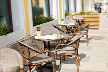 Cafe table on the street wicker chair and round table, urban restaurant bistro on the street of the city
