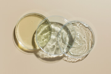 Various cosmetic products in Petri dishes on beige background view from above