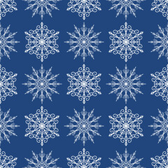 Seamless pattern with white snowflakes on a blue background. Winter backdrop.