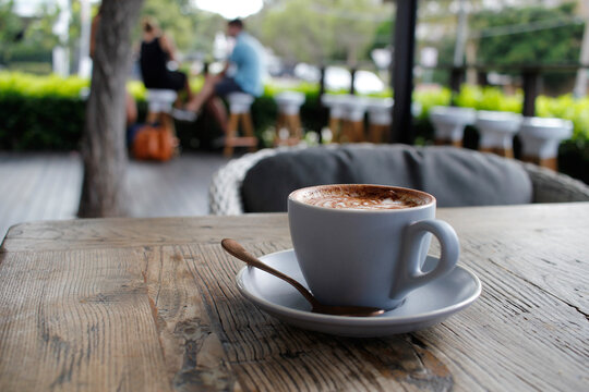 Cup of coffee sitting on an outdoor table at a cafe