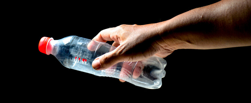 The problem of plastic waste and pollution from plastic waste Hands collecting plastic waste on black background. Environment love concept. The images are easy to implement in projects.