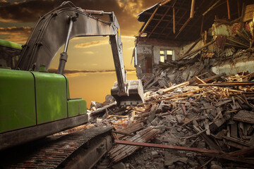 Fototapeta na wymiar Powerful crawler excavator demolishes an old building