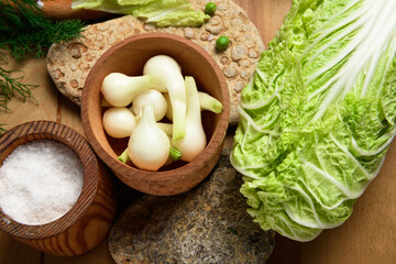 vegetables on a wooden kitchen board, cabbage, onions and peas on a wood background, concept of fresh and healthy food, still life