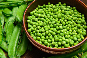 green sweet peas on a dark wooden background, still life, concept of fresh and healthy food