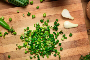 vegetables on a wooden kitchen board, sliced green onions, peas on a wood background, concept of fresh and healthy food, still life
