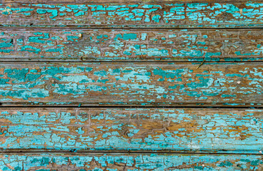 old boards as an abstract wooden background, painted with green paint that peels off
