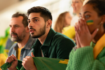 Brazilian football fans supporting their team at stadium.