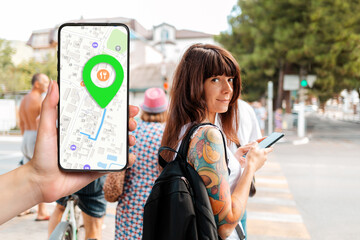 A hand holds a smartphone with an online map app and a marked destination. In the background, a...