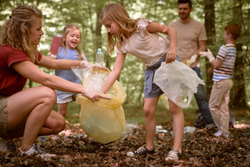 Caucasian family cleaning forest from garbages