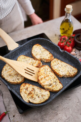 Sliced bread fried on grill frying pan at domestic kitchen