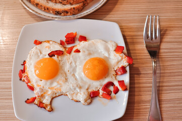 Two Fried eggs on pan with red pepper morning breakfast . High quality photo