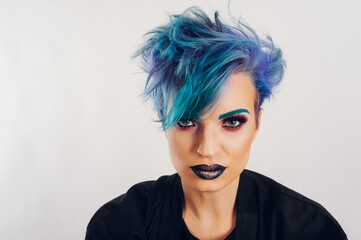 Portrait of a woman with colorful vivid makeup on a white studio background
