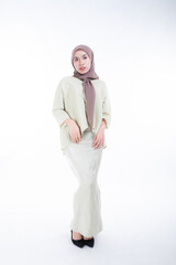 Fototapeta premium Beautiful female model in poses wearing traditional apparel and hijab, an urban lifestyle look for Muslim women isolated on white background. Beauty and hijab fashion concept. Full length